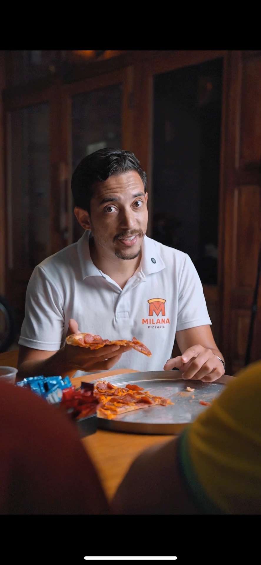 Milana Pizzaria — dono da pizzaria com uniforme da marca